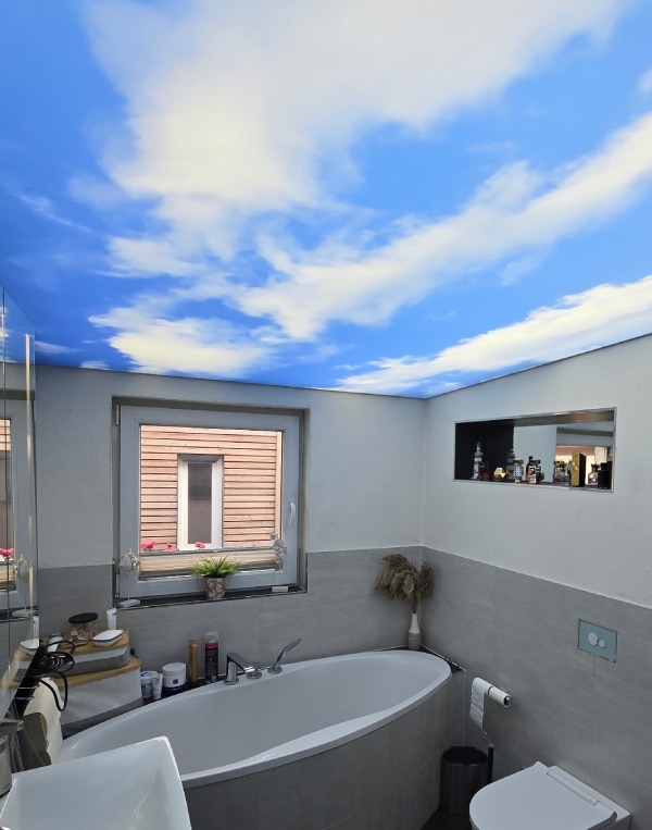 hinterleuchtete Motivdecke mit Wolkenhimmel in einem Badezimmer
